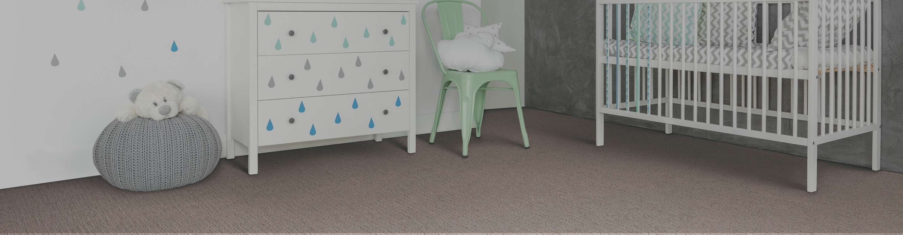brown carpet in a nursery with crib and green chair